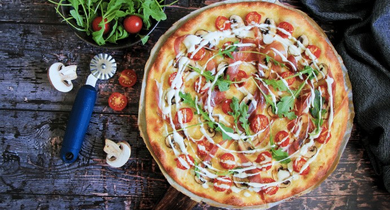 Pizza blanche aux tomates, jambon de parme, champignons et roquette