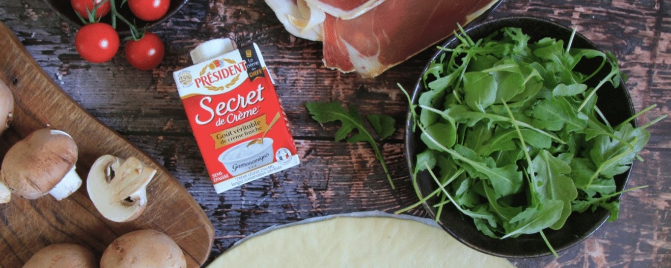 Pizza blanche aux tomates, jambon de parme, champignons et roquette