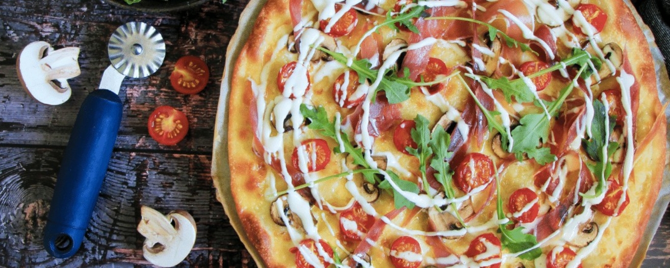 Pizza blanche aux tomates, jambon de parme, champignons et roquette