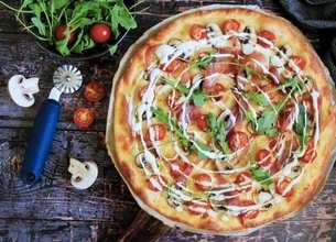 Pizza blanche aux tomates, jambon de parme, champignons et roquette